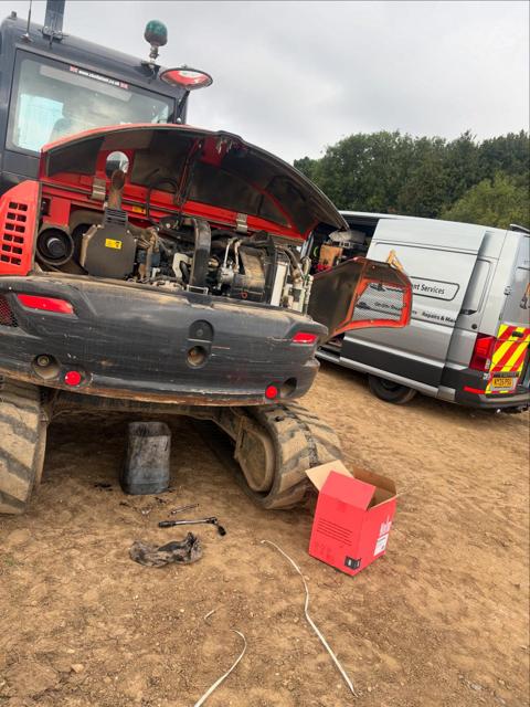 Engineer servicing an excavator next to the LCA van