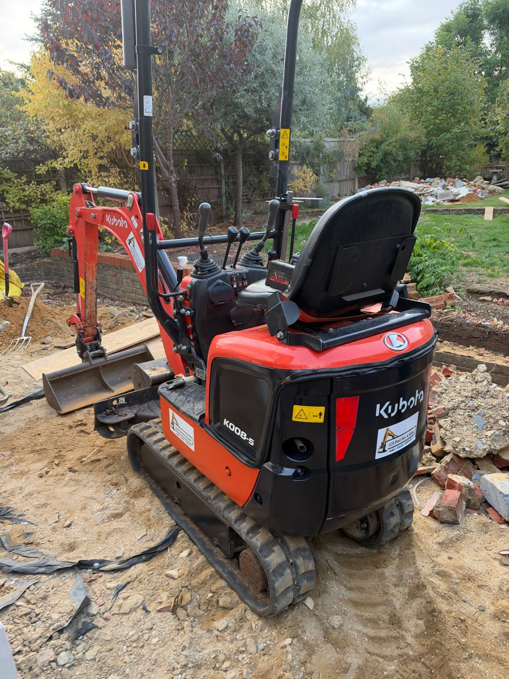 Kubota K008 micro digger with LCA Plant Hire & Sales stickers, on a garden job